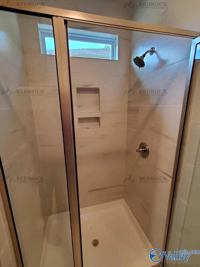 bathroom featuring a shower with door