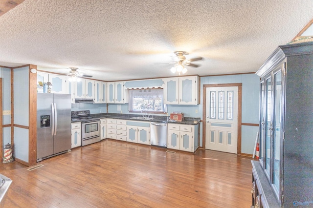 kitchen featuring white cabinetry, stainless steel appliances, light hardwood / wood-style floors, and ceiling fan