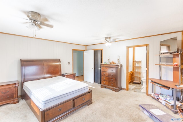 bedroom with light carpet, crown molding, ensuite bath, and ceiling fan