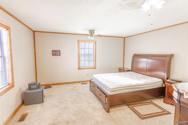 bedroom featuring multiple windows, carpet, a textured ceiling, and ceiling fan