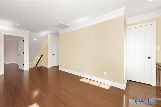 spare room featuring ornamental molding and dark wood-type flooring