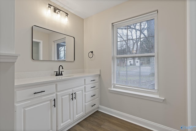 bathroom featuring baseboards, wood finished floors, and vanity