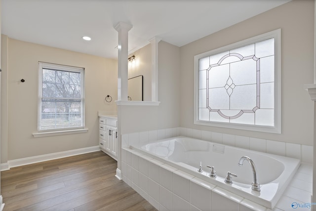 full bath with baseboards, a garden tub, recessed lighting, wood finished floors, and vanity