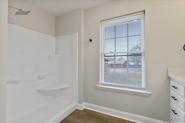 full bathroom with vanity, wood finished floors, baseboards, visible vents, and a shower