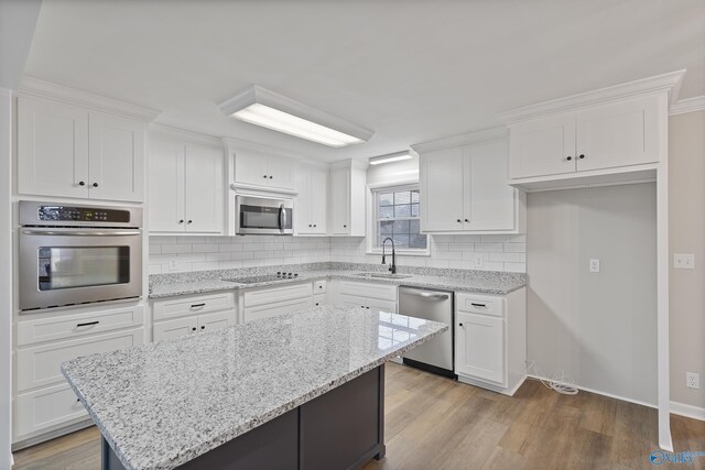 kitchen featuring white cabinets, stainless steel appliances, and a sink