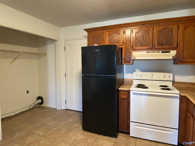 kitchen with light tile patterned floors, black refrigerator, a textured ceiling, and white range with electric stovetop