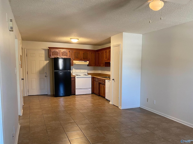 kitchen with white appliances, a textured ceiling, and tile patterned flooring