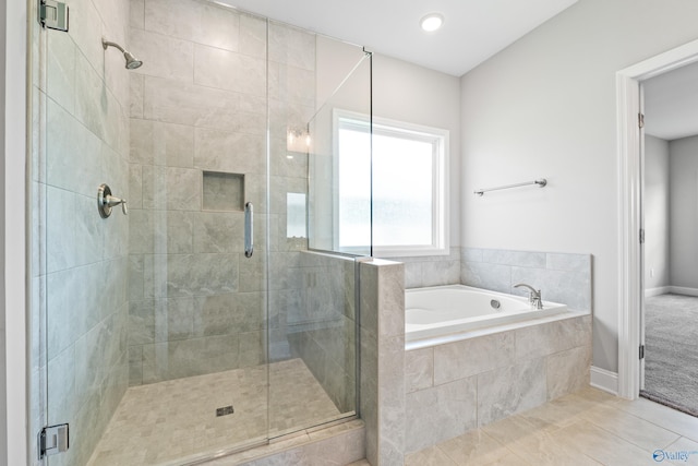 full bathroom featuring a shower stall, a bath, and tile patterned floors