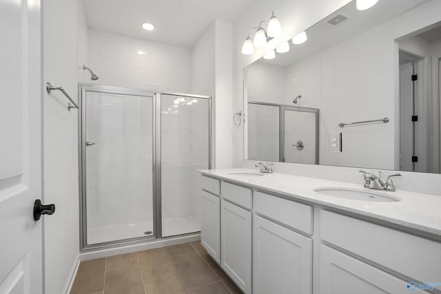 bathroom with tile patterned floors, a shower with door, and vanity