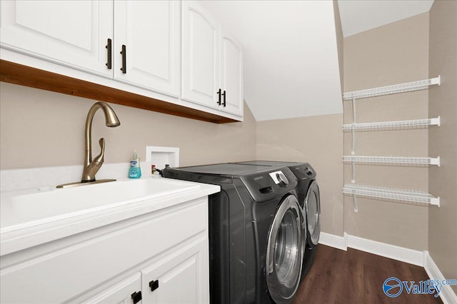 laundry area featuring sink, cabinets, washer and clothes dryer, and dark hardwood / wood-style floors