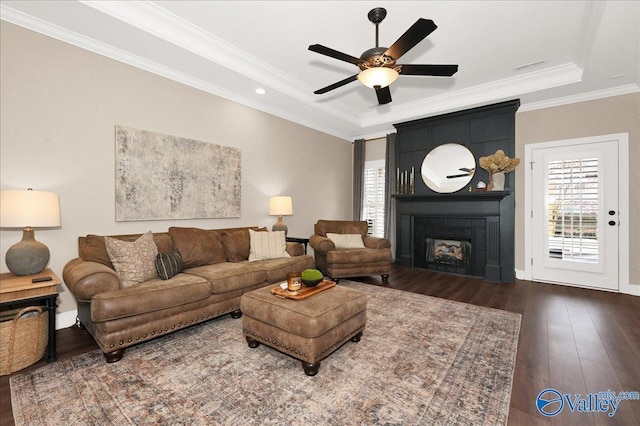 living room featuring a fireplace, ceiling fan, ornamental molding, and dark hardwood / wood-style flooring