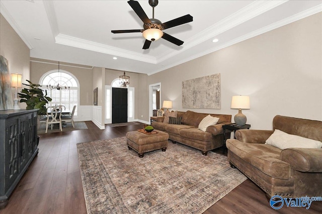 living room with ceiling fan, dark wood-type flooring, crown molding, and a tray ceiling