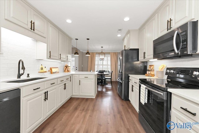 kitchen with appliances with stainless steel finishes, white cabinetry, pendant lighting, and sink