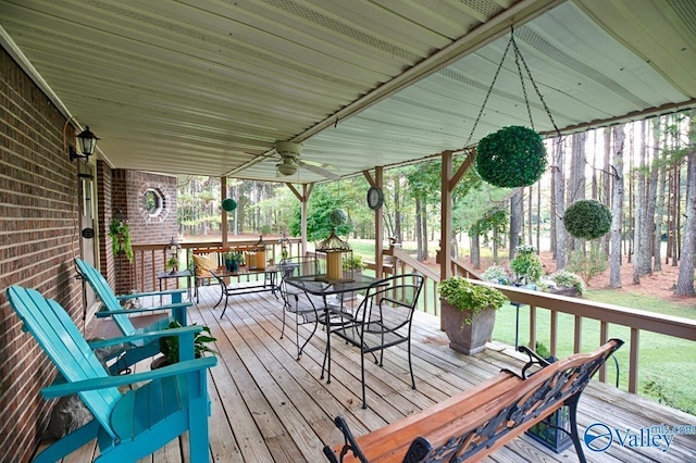 wooden terrace with outdoor dining area and ceiling fan