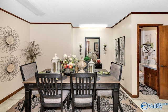dining space with light tile patterned flooring, baseboards, ornamental molding, and a textured ceiling