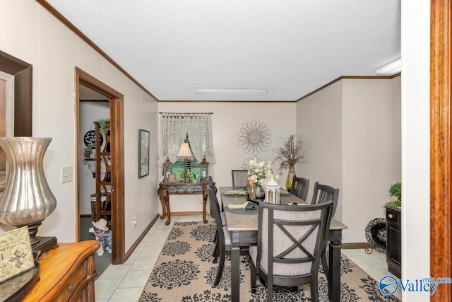 dining room with crown molding, a textured ceiling, and light tile patterned floors