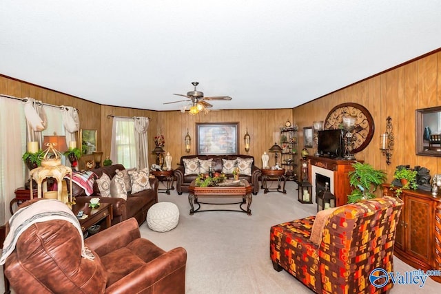 carpeted living room featuring wooden walls and a ceiling fan