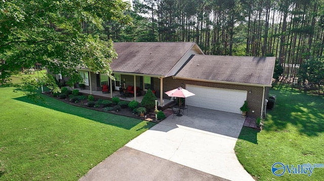 view of front of property featuring brick siding, a garage, a porch, a front yard, and driveway