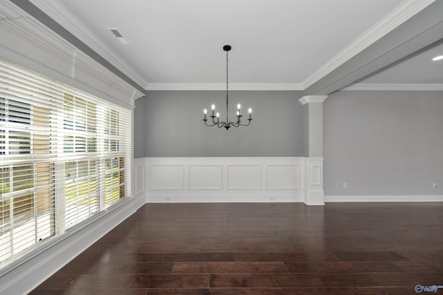 unfurnished dining area with a notable chandelier, ornamental molding, dark wood-type flooring, and ornate columns