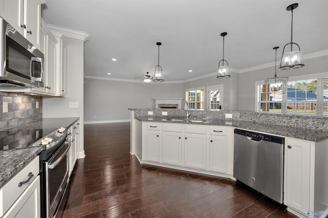 kitchen featuring white cabinets, appliances with stainless steel finishes, dark wood-type flooring, and a healthy amount of sunlight