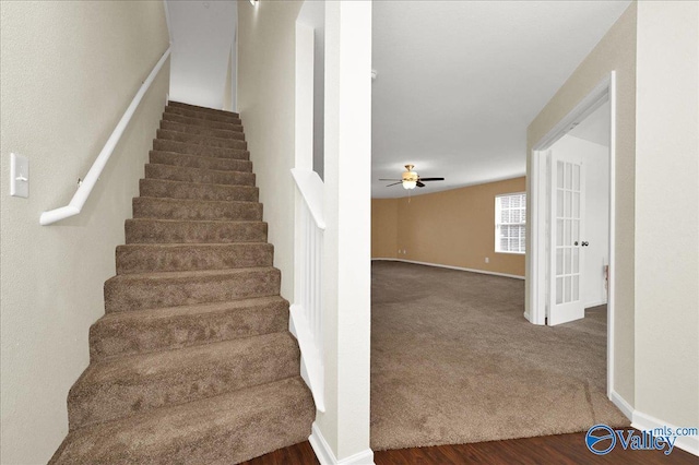 stairs with carpet, ceiling fan, baseboards, and wood finished floors