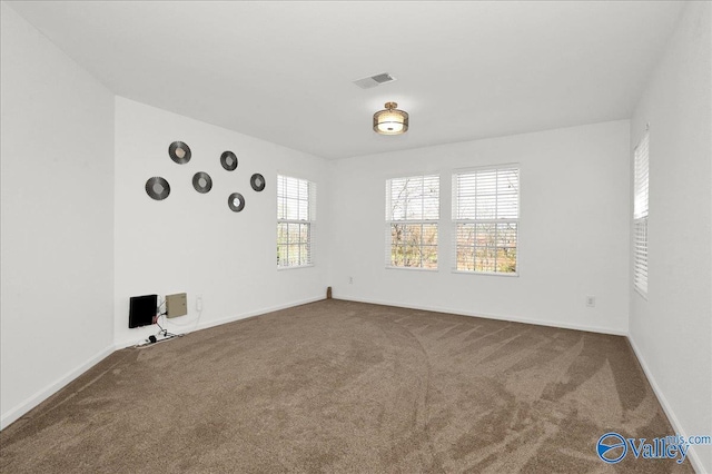 carpeted empty room featuring visible vents and baseboards