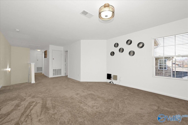 carpeted spare room with visible vents and baseboards