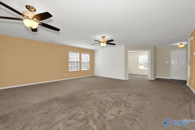 interior space with dark carpet, a ceiling fan, and baseboards