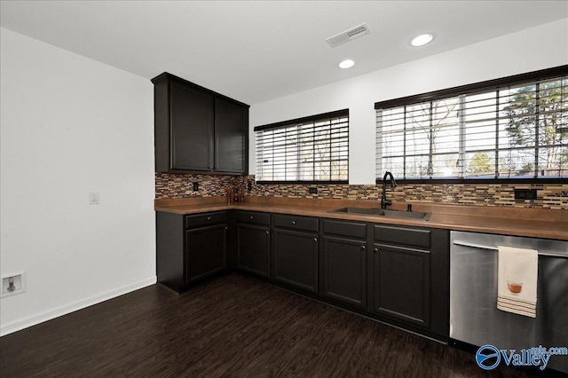 kitchen featuring a sink, visible vents, dark wood-style floors, dishwasher, and tasteful backsplash