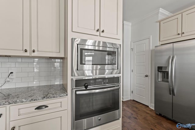 kitchen with light stone counters, stainless steel appliances, ornamental molding, backsplash, and dark wood-type flooring