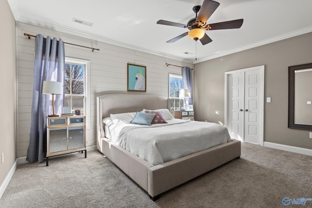 bedroom with carpet floors, crown molding, visible vents, and baseboards