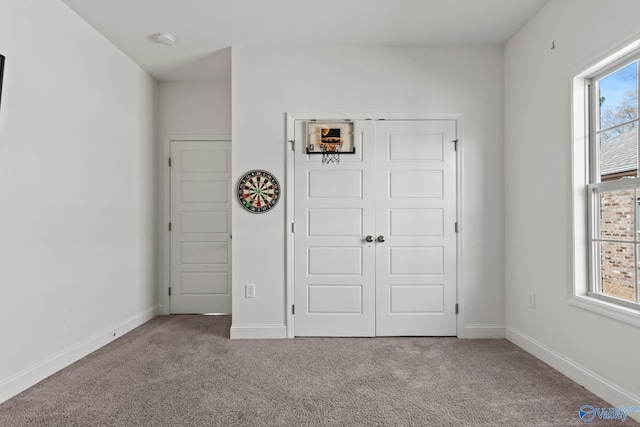 unfurnished bedroom featuring a closet, carpet, and baseboards