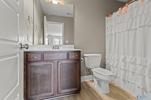 bathroom with curtained shower, visible vents, toilet, vanity, and baseboards