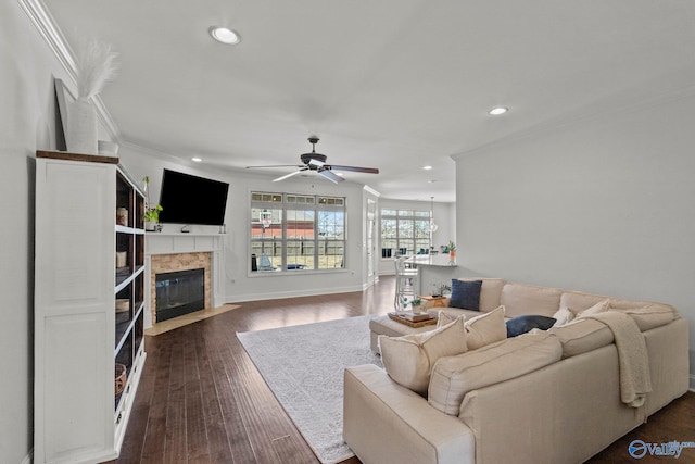 living area with a ceiling fan, recessed lighting, crown molding, and a fireplace