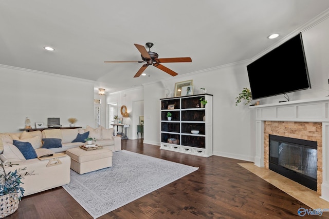living room with a ceiling fan, wood finished floors, a fireplace, and crown molding