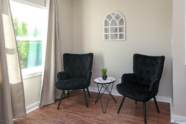 sitting room with baseboards and wood finished floors