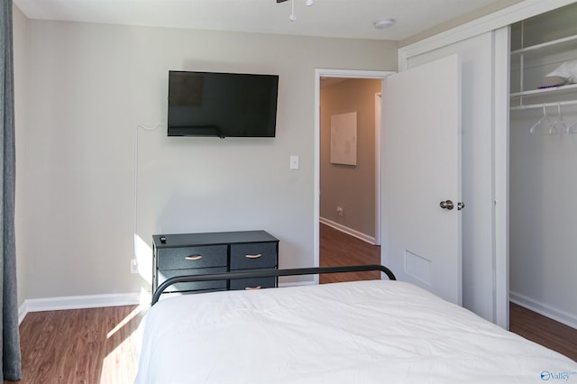 bedroom featuring a closet, baseboards, and wood finished floors