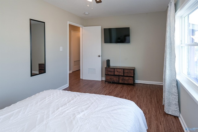 bedroom with a ceiling fan, baseboards, and wood finished floors