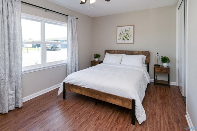 bedroom featuring a closet, ceiling fan, baseboards, and wood finished floors