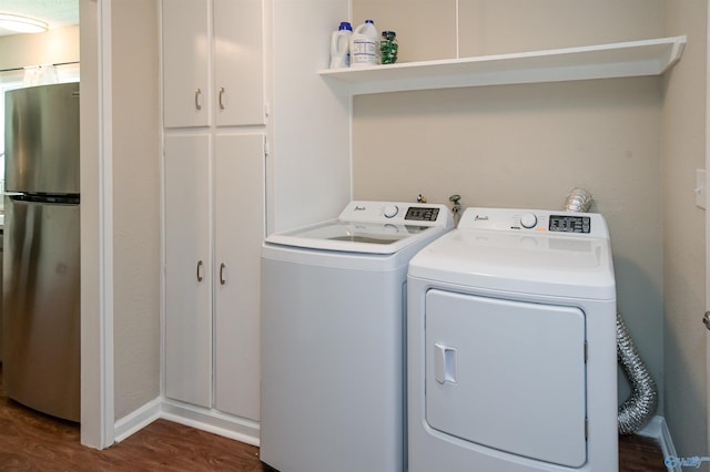 laundry room with cabinet space, baseboards, washer and clothes dryer, and dark wood finished floors