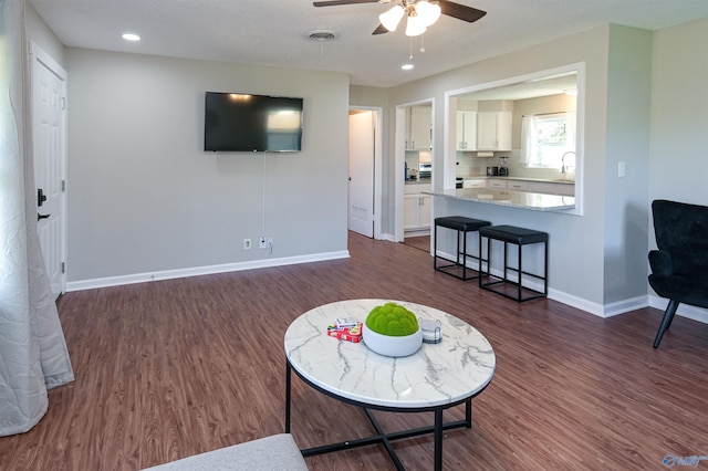 living area featuring recessed lighting, dark wood finished floors, visible vents, and baseboards