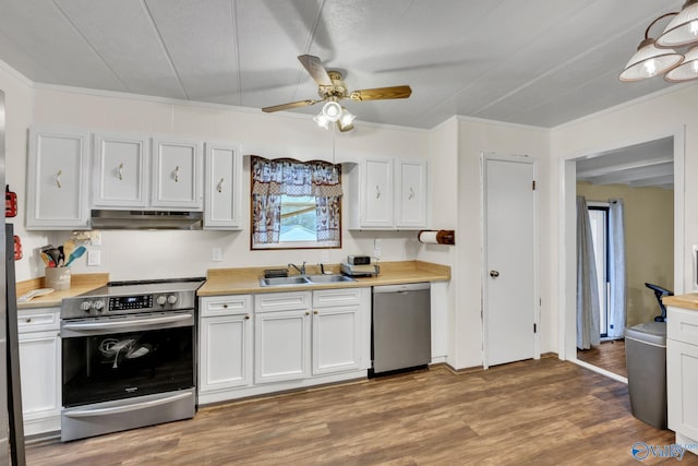 kitchen with appliances with stainless steel finishes, light wood-type flooring, white cabinetry, and sink