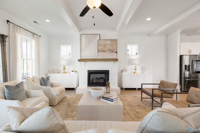 living room with ceiling fan, a brick fireplace, radiator heating unit, and beam ceiling