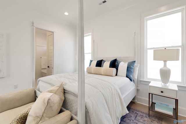 bedroom with dark wood-type flooring and ensuite bathroom