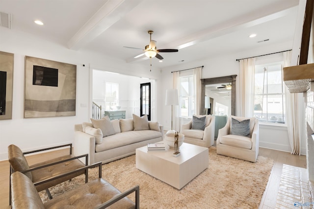 living room featuring ceiling fan, beam ceiling, and light hardwood / wood-style flooring