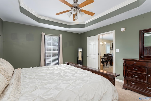 carpeted bedroom featuring ceiling fan with notable chandelier, a raised ceiling, and crown molding