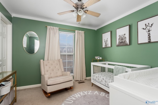 bedroom with light carpet, a nursery area, crown molding, and ceiling fan