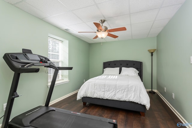 bedroom with a paneled ceiling, ceiling fan, and dark hardwood / wood-style floors