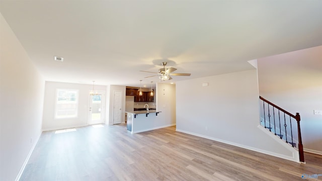 209 Roman Randall Rd, New Market, AL 35761 - unfurnished living room featuring stairs, light wood finished floors, baseboards, and ceiling fan