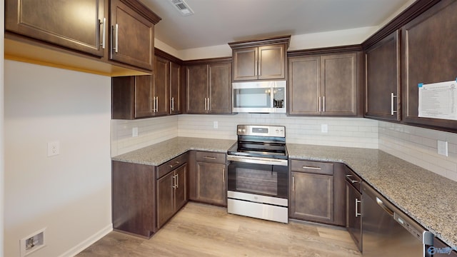 209 Roman Randall Rd, New Market, AL 35761 - kitchen featuring appliances with stainless steel finishes, dark brown cabinets, backsplash, light wood-style flooring, and light stone counters